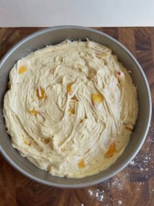 Spread the peach cake better in a pan.