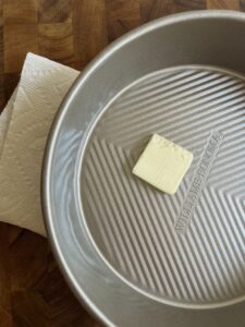 Grease your cake pan just with a paper towel and a little butter.