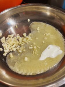 Garlic cooking in butter in a skillet.