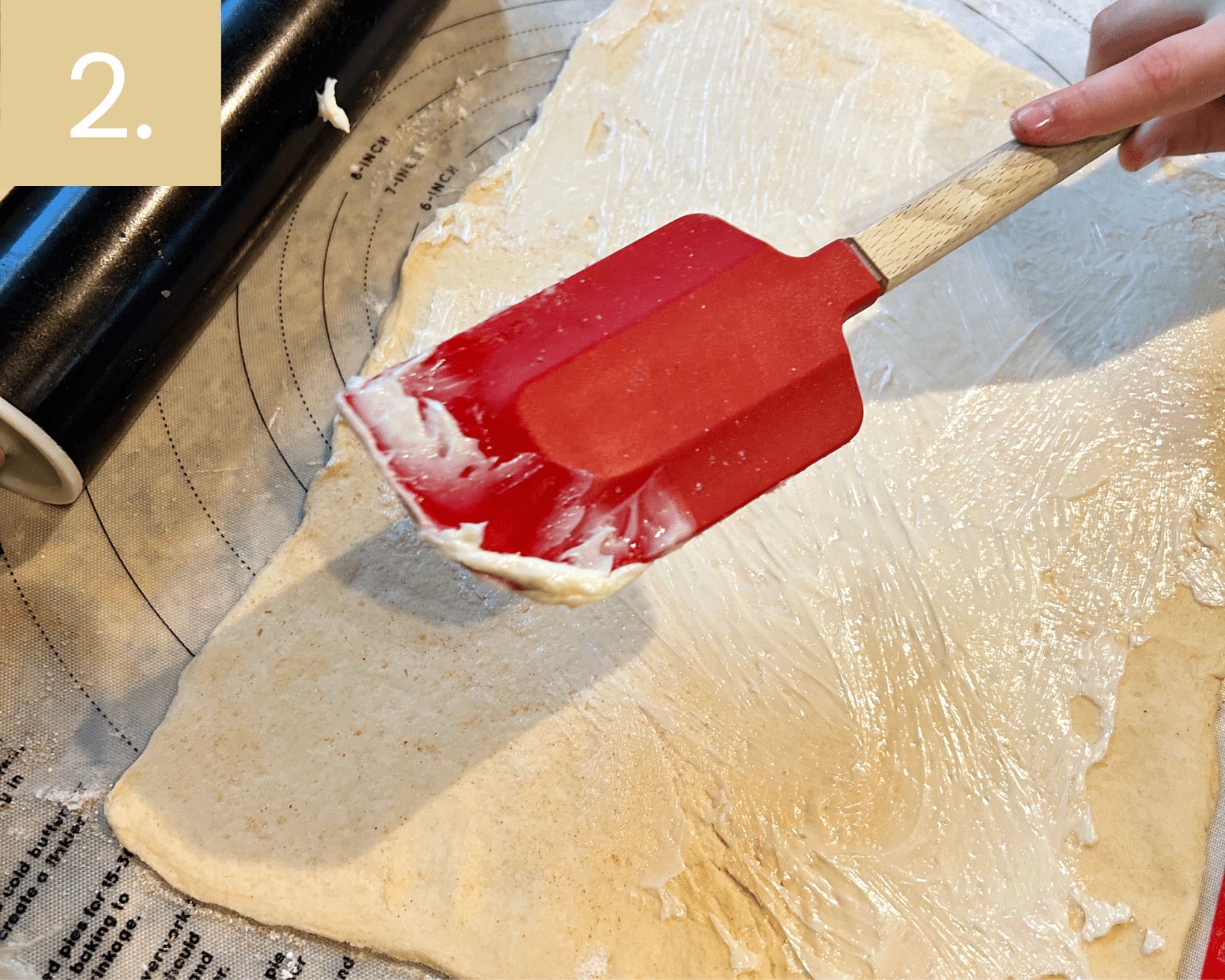 Brushing softened butter over crescent dough sheet for cruffins recipe.