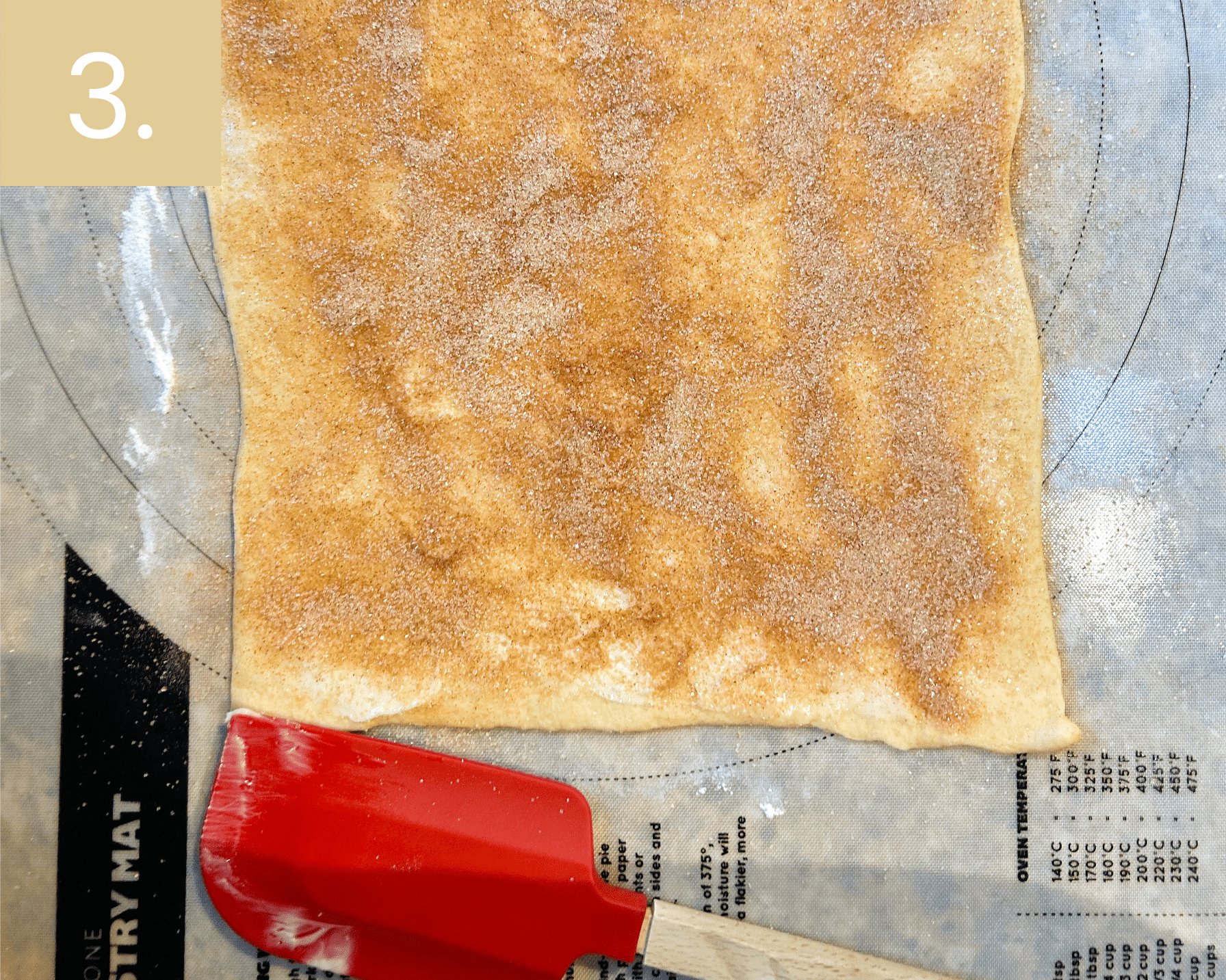 Sprinkling cinnamon sugar mixture evenly over buttered dough for cruffins.